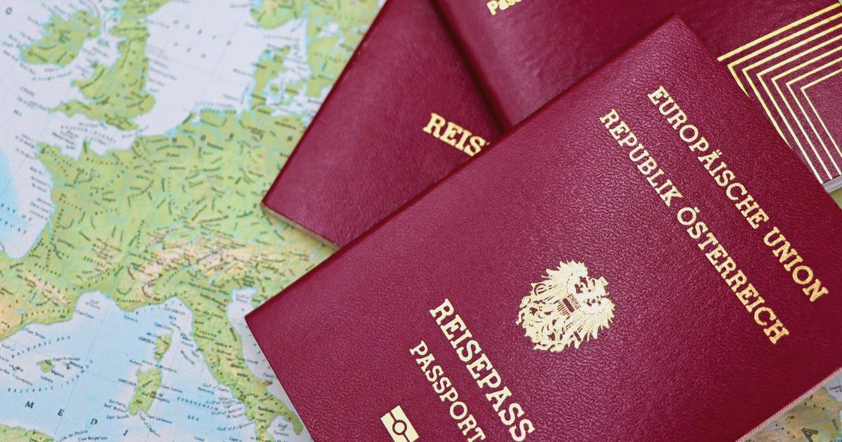 Close-up of European passports from Portugal and Austria on a world map.
