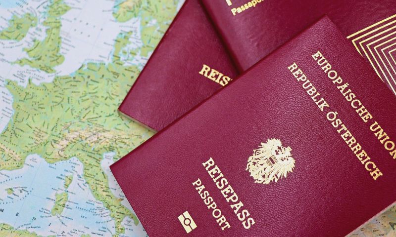Close-up of European passports from Portugal and Austria on a world map.