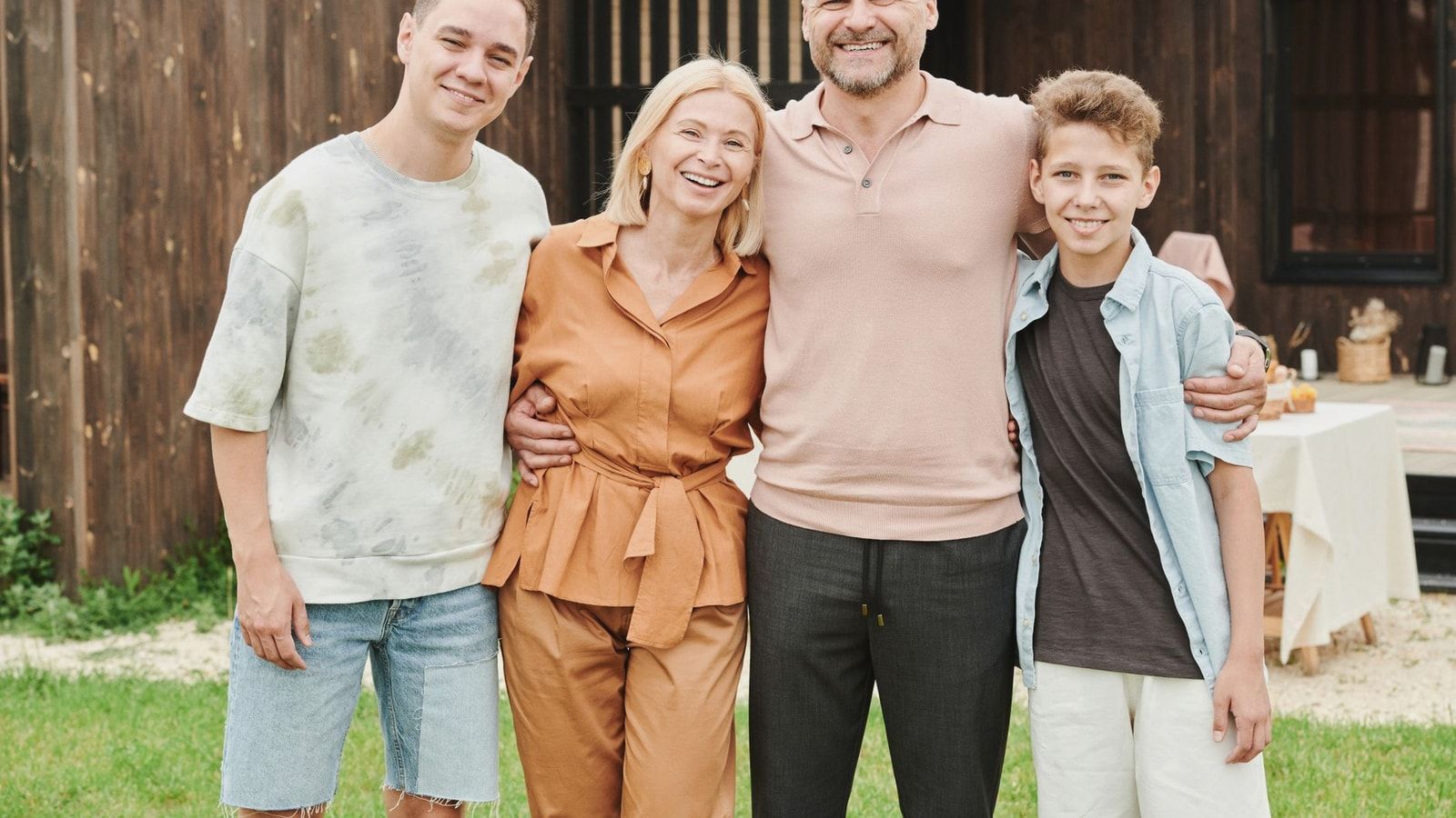 Smiling family of four posing outdoors, capturing love and togetherness.