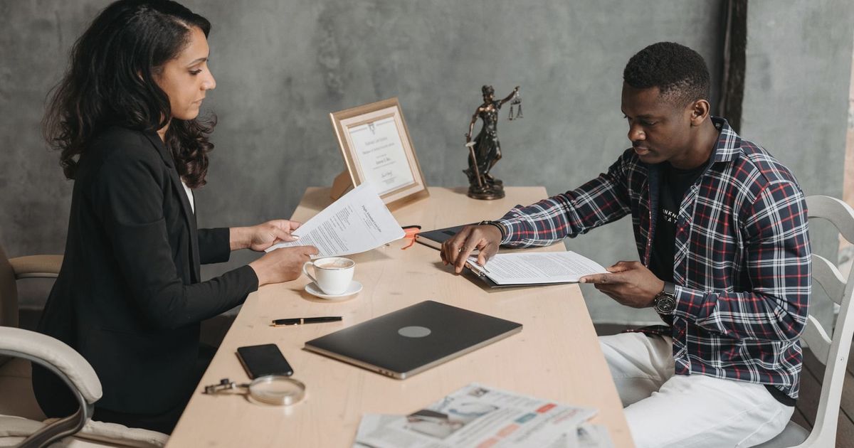 Business professionals discussing documents in a modern office setting.