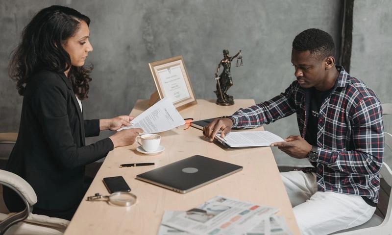 Business professionals discussing documents in a modern office setting.