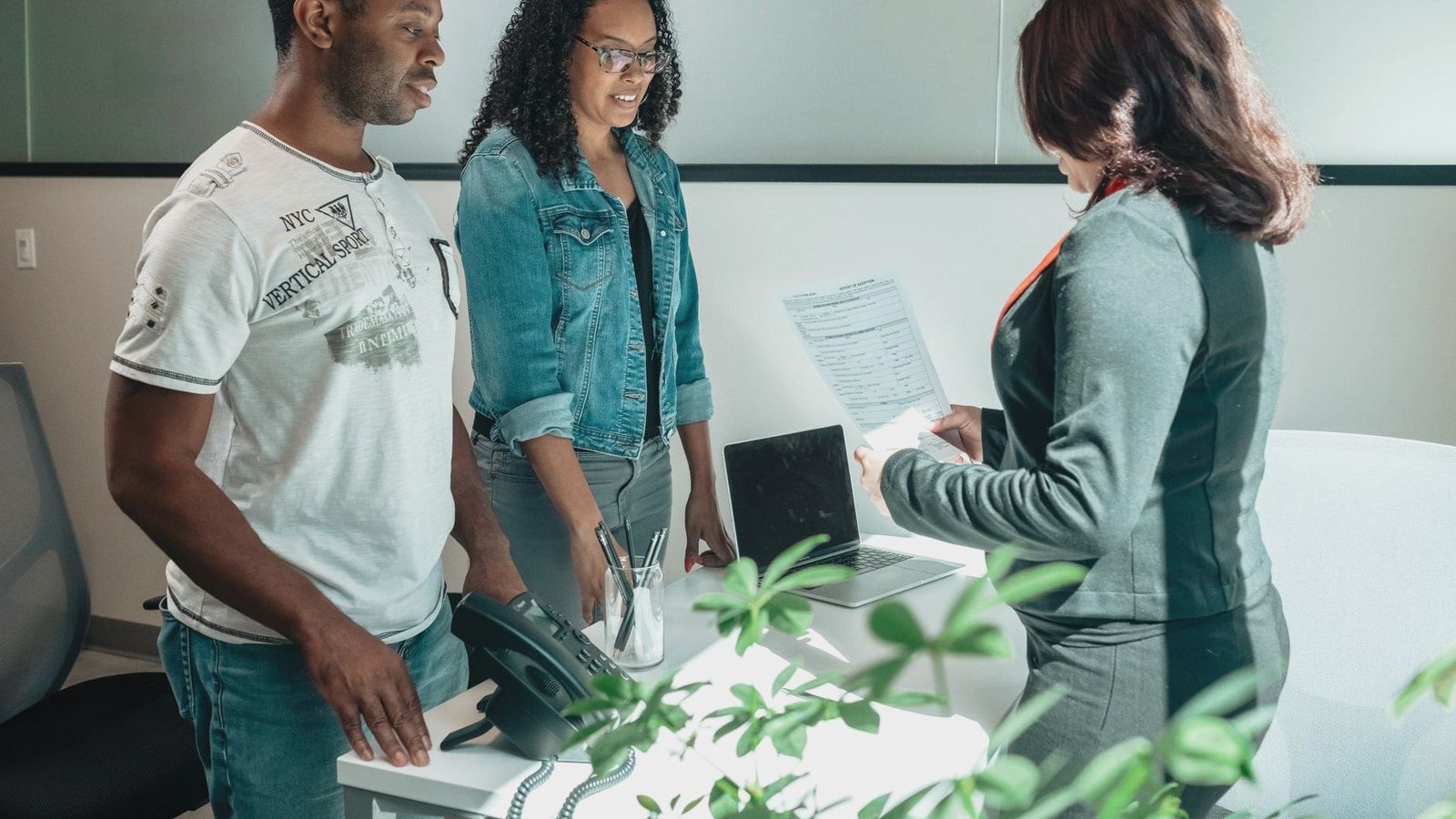 A diverse group in a business meeting discussing documents in a modern office setting.