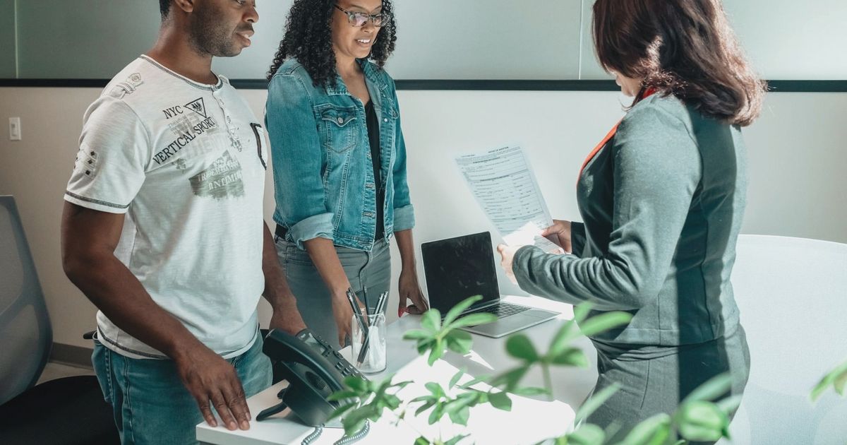 A diverse group in a business meeting discussing documents in a modern office setting.