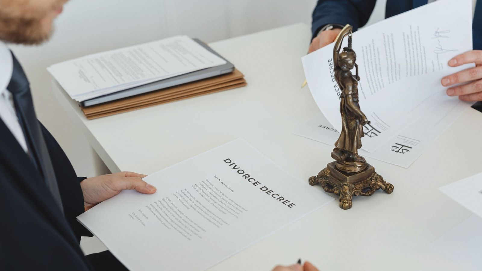 Two professionals discuss divorce decree documents, focusing on legal negotiations.