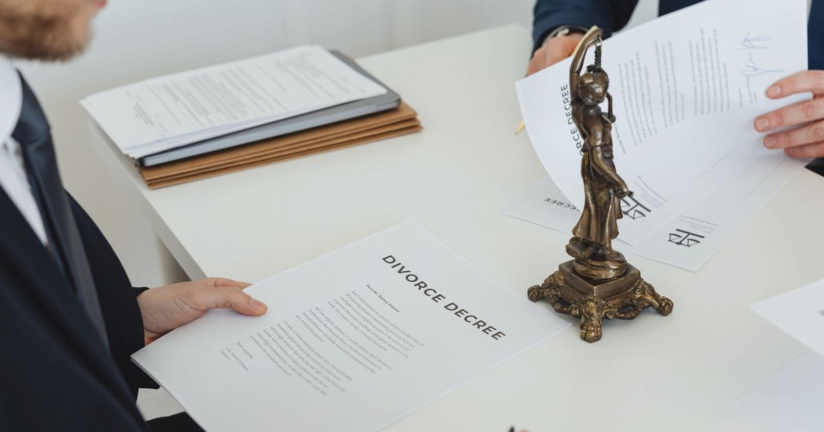 Two professionals discuss divorce decree documents, focusing on legal negotiations.