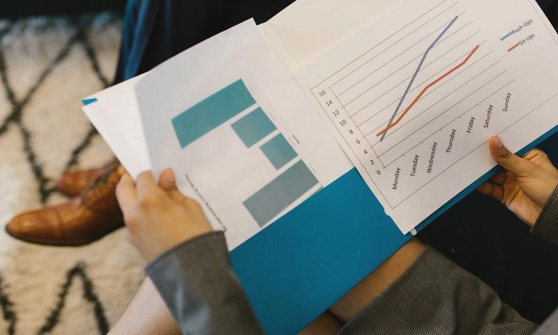 Detailed view of business reports with graphs during a corporate meeting.