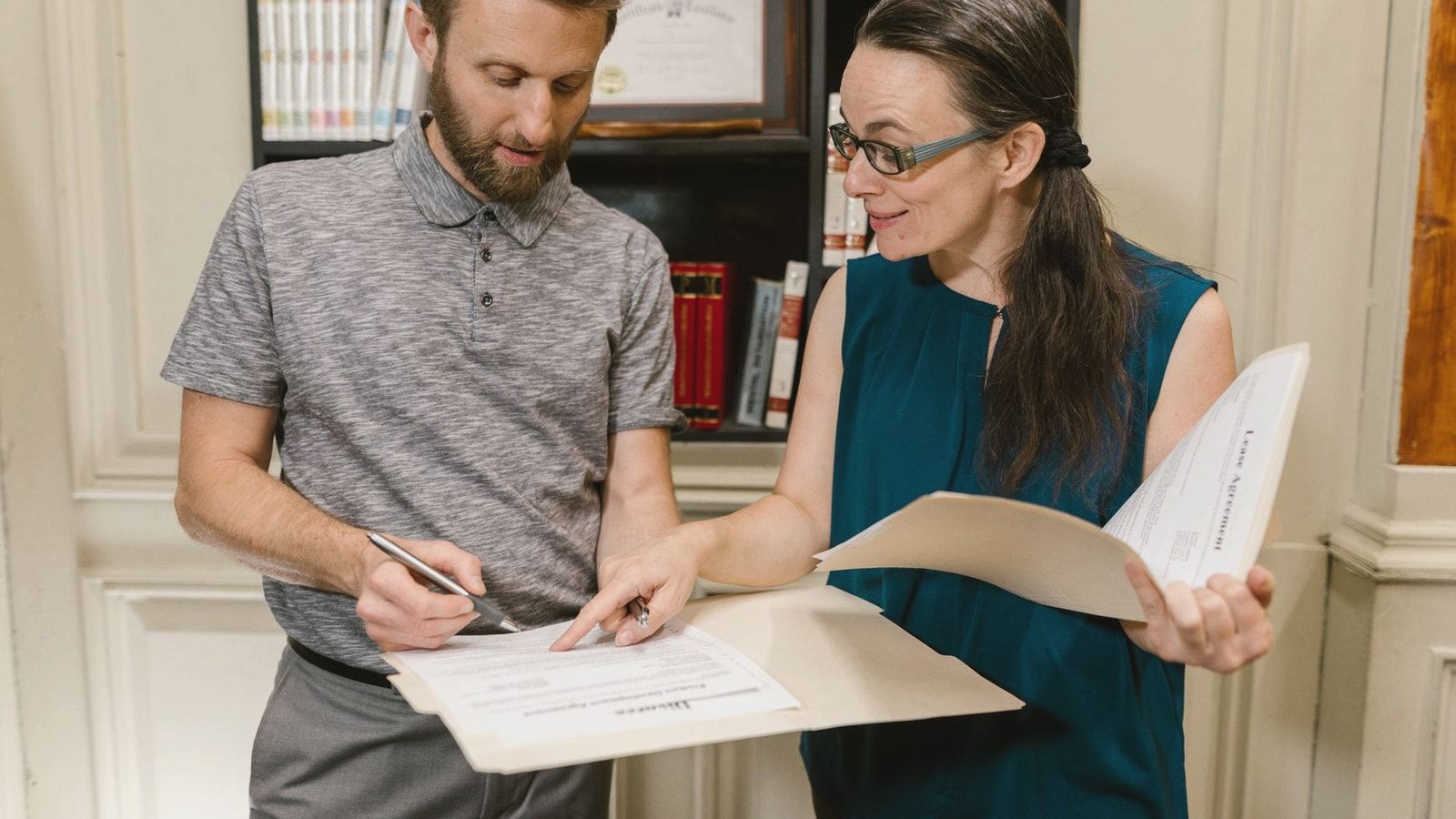 Two adults reviewing documents during a legal consultation in an office setting.