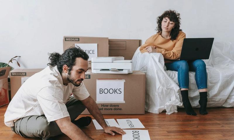 Couple organizing labels for packing and moving in a modern home setting.