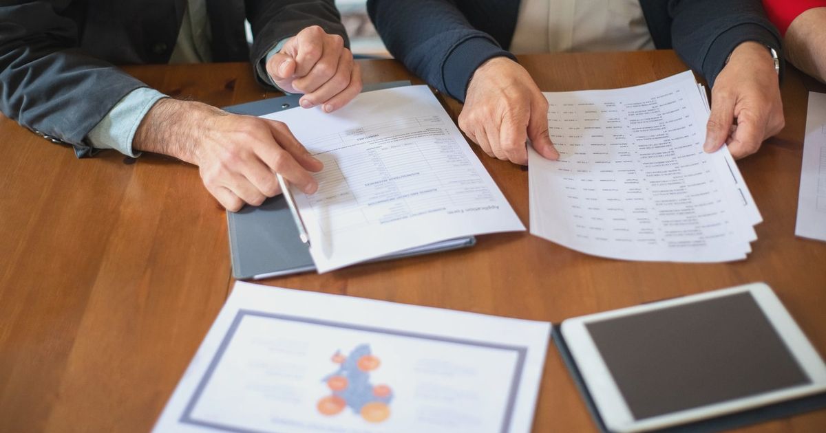 Two business professionals discussing and reviewing documents during a meeting.