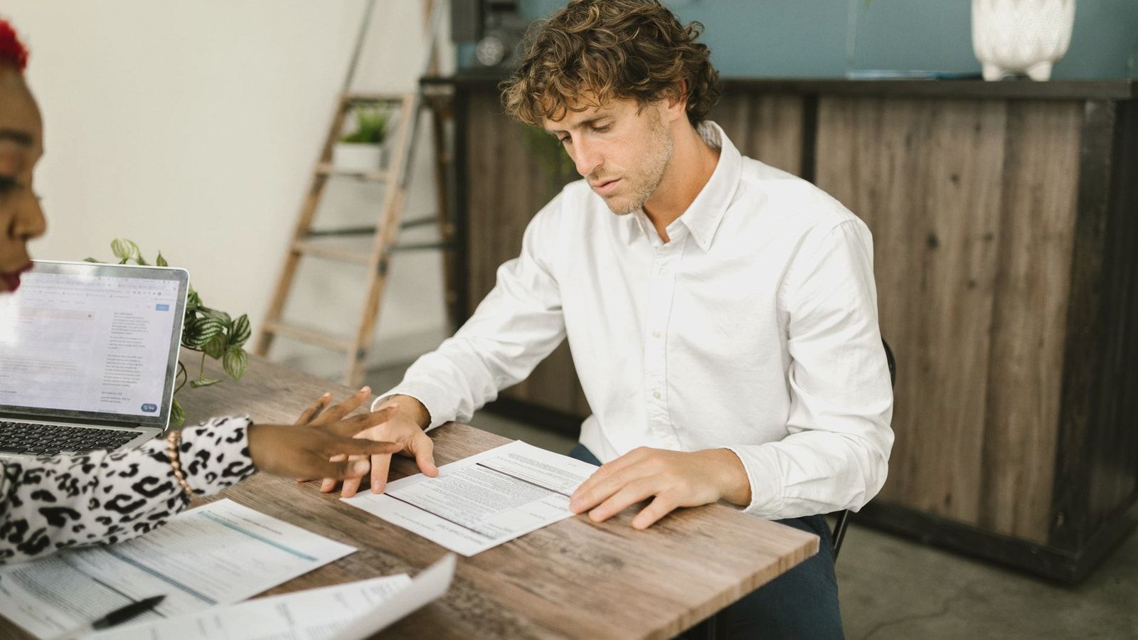 Two professionals discussing financial documents in an office setting.