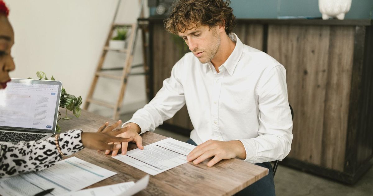 Two professionals discussing financial documents in an office setting.