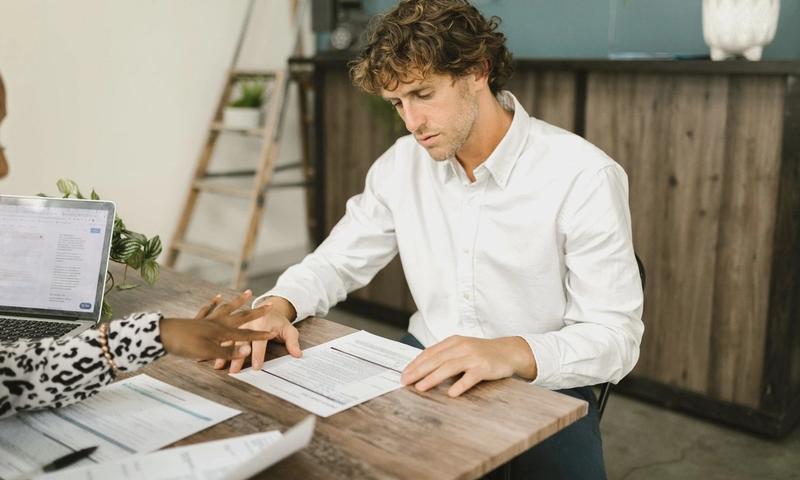 Two professionals discussing financial documents in an office setting.