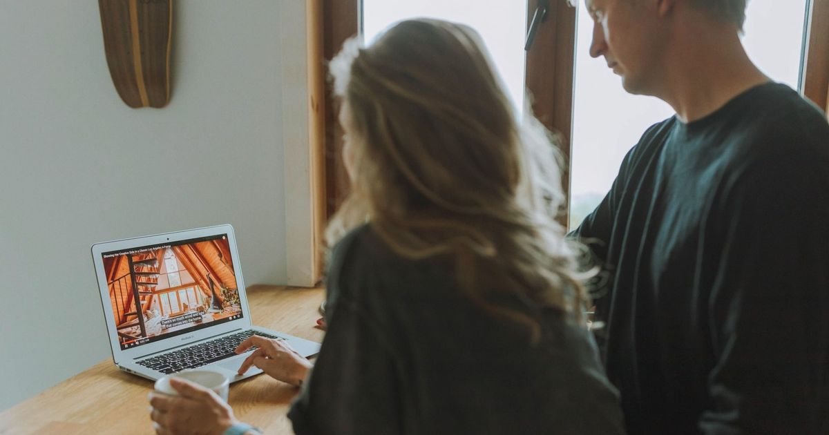 A couple viewing home interior design on a laptop while enjoying coffee together indoors.