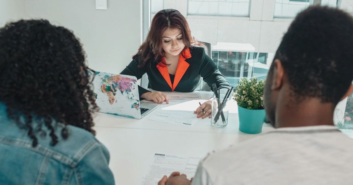 A couple discussing legal documents with a lawyer in a modern office environment.