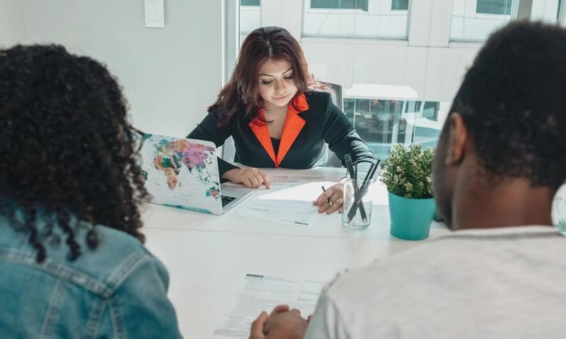 A couple discussing legal documents with a lawyer in a modern office environment.