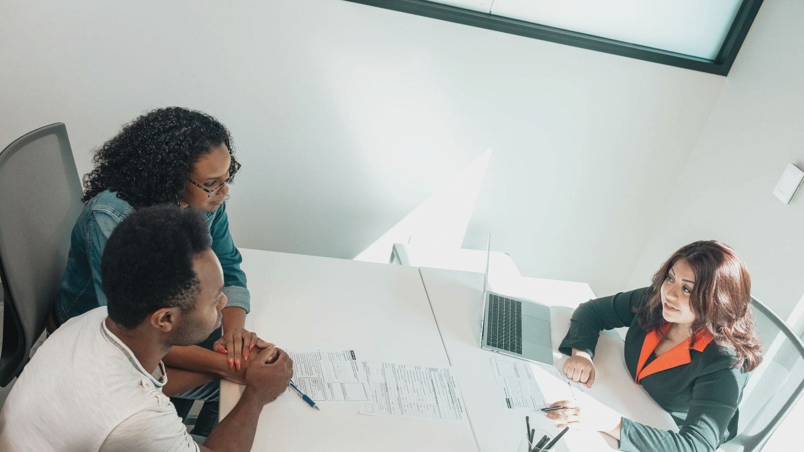 Diverse group discussing business documents in a bright, modern office setting.
