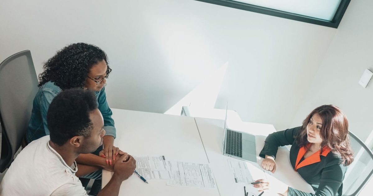 Diverse group discussing business documents in a bright, modern office setting.