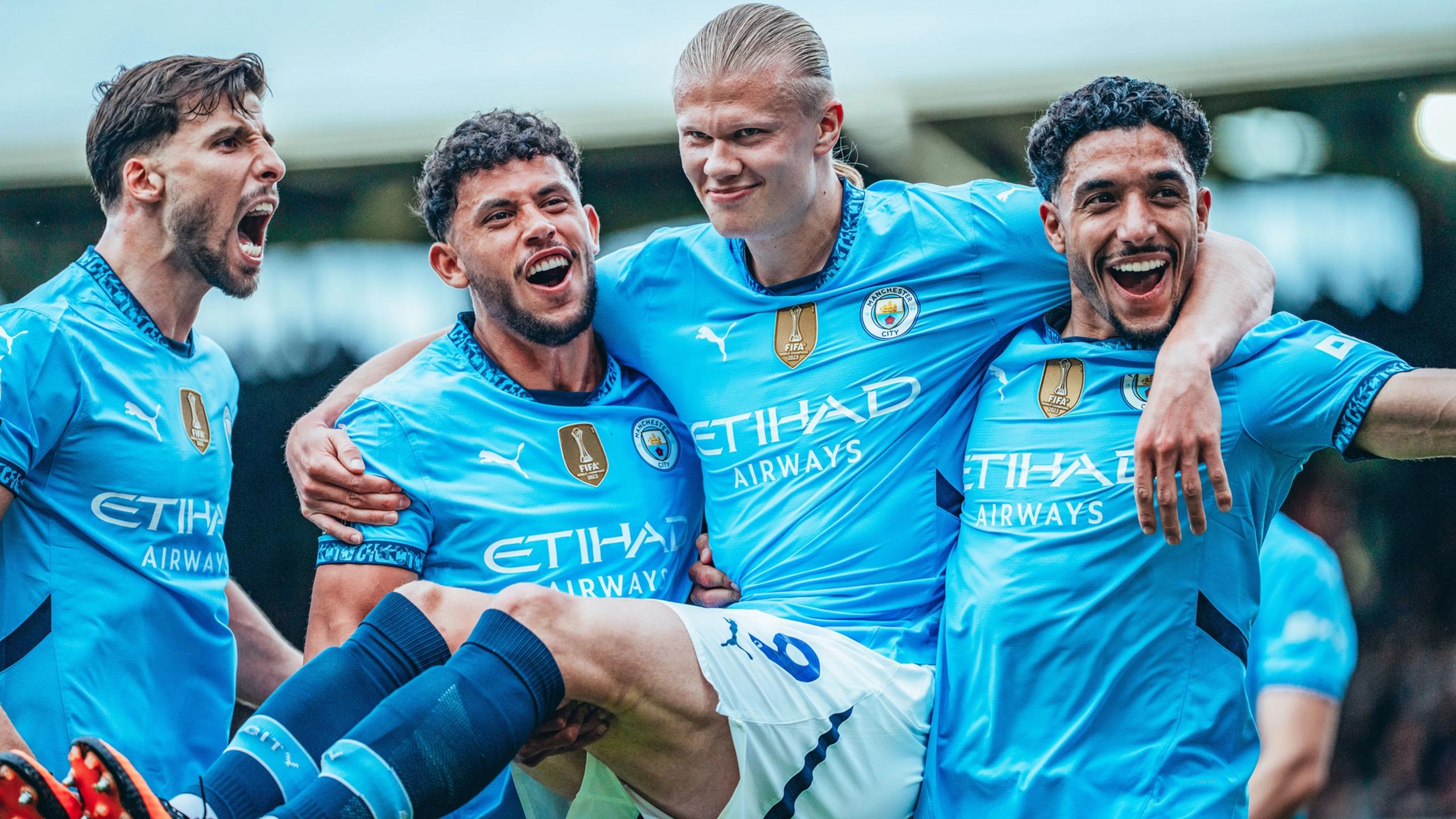 Manchester City hospitality guests cheer as Haaland and Nunes celebrate a goal in Puma kits.