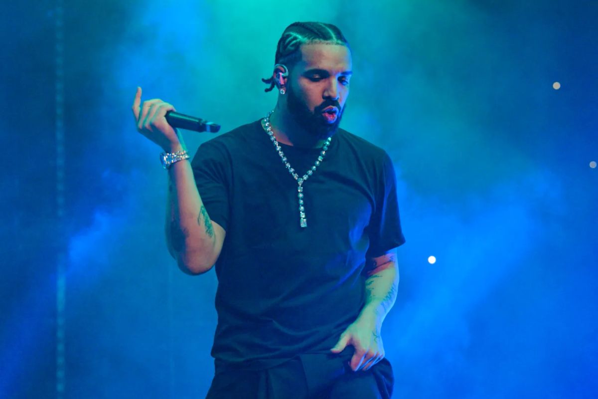 Drake performs live concert on stage with blue lighting