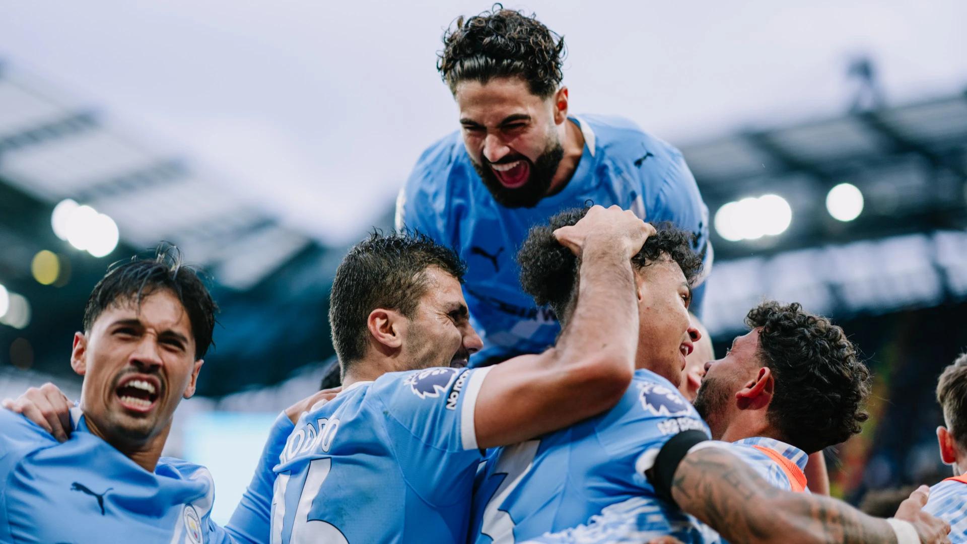 Rodri and Manchester City hospitality guests cheer a goal in blue Puma kits at St James' Park.