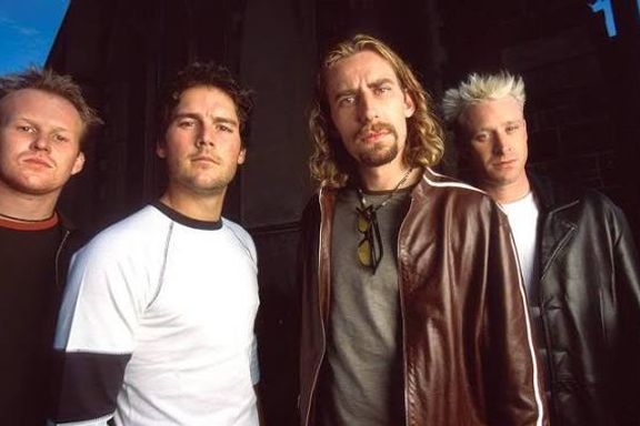 An older Nickelback band photo, Chad Kroeger in a brown leather jacket with sunglasses hooked on his shirt
