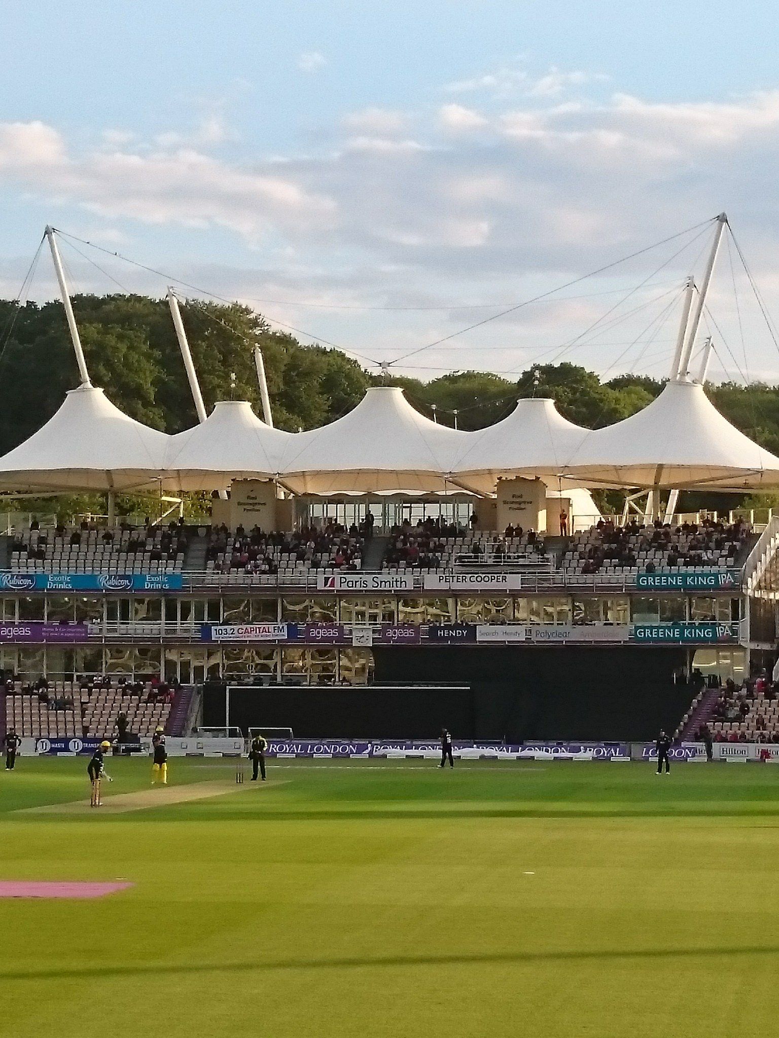 The white tented roof of the pavilion at the Utilita Bowl in Southampton on a summer evening, with a match in progress on the outfield below