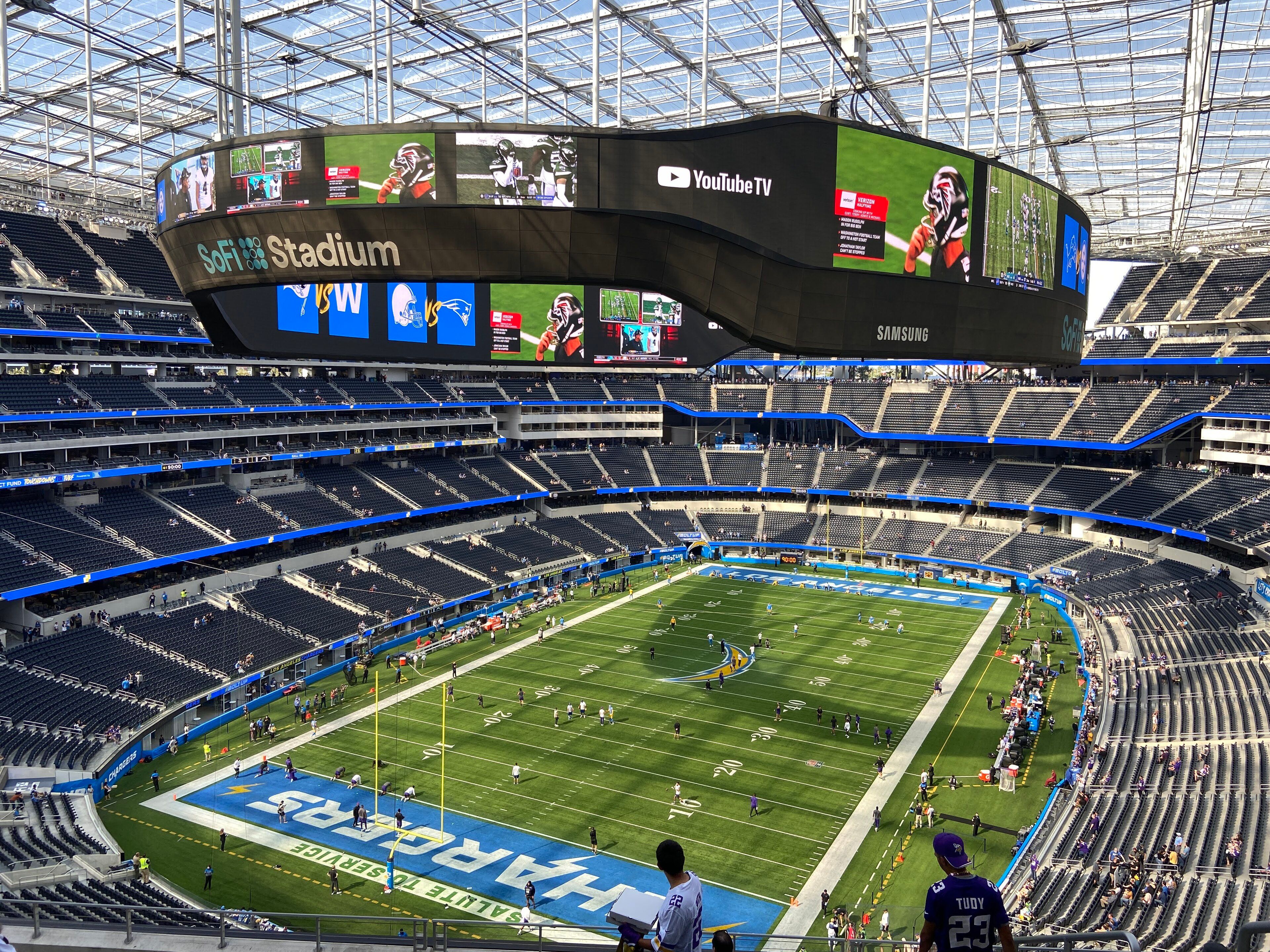 Inside SoFi Stadium during an NFL game in November 2021, with the video board hanging above the field