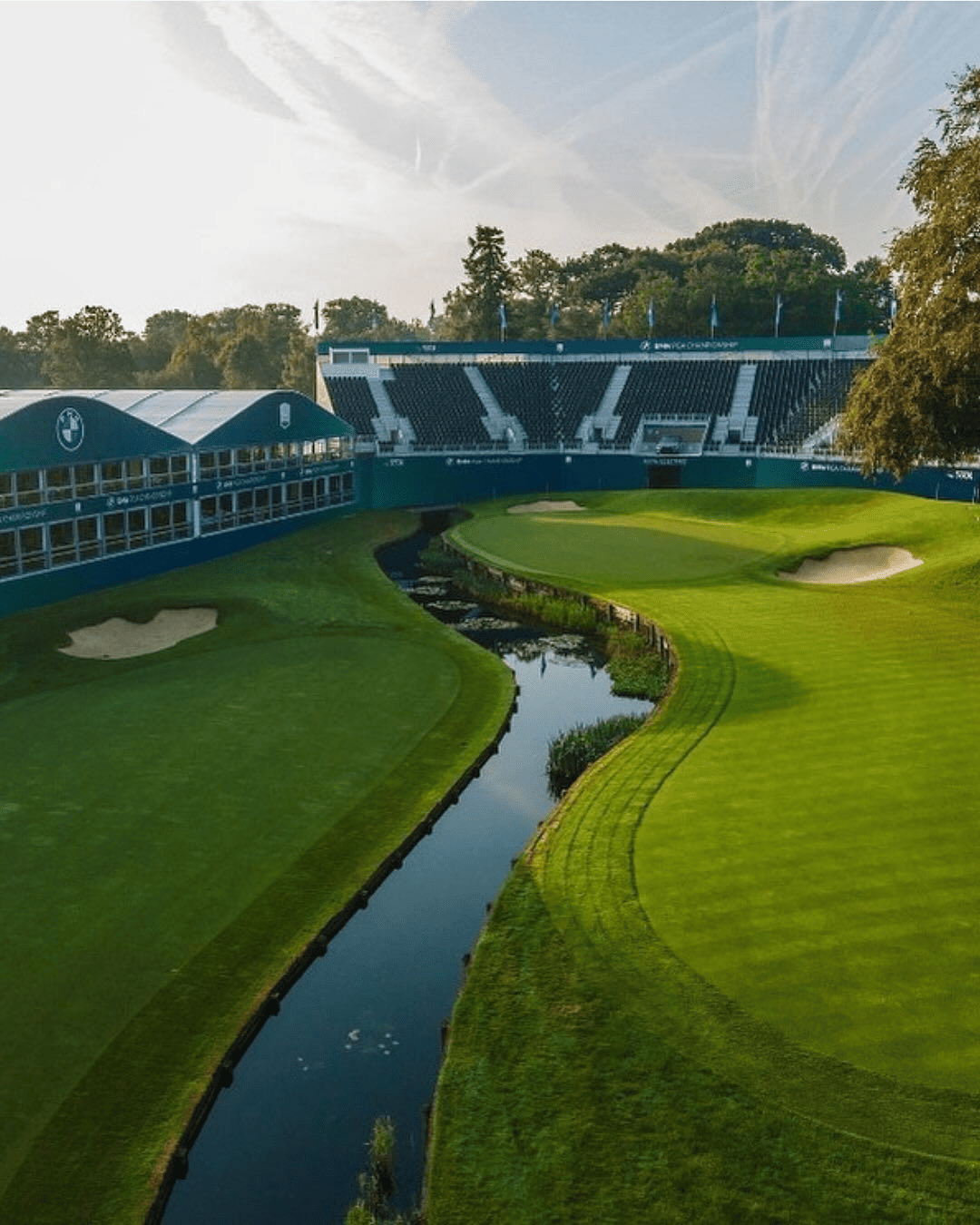 Aerial view of BMW PGA Championship golf course: hospitality suites, grandstand, water hazard.