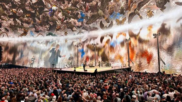 U2 performing on stage inside the Sphere in Las Vegas in February 2024, with the dome screen lit above the crowd