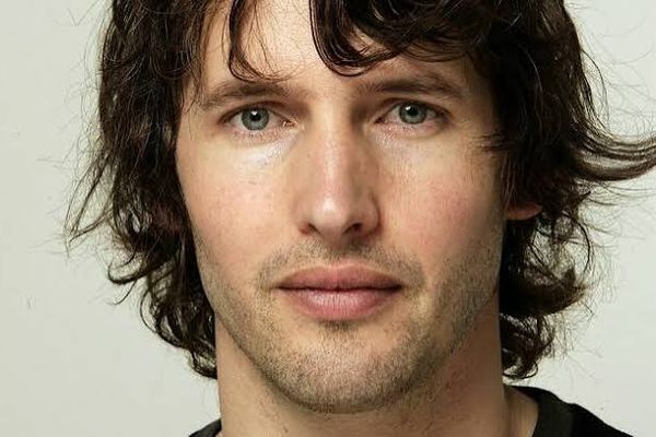 Close-up of a younger James Blunt with shoulder-length dark hair against a plain pale background