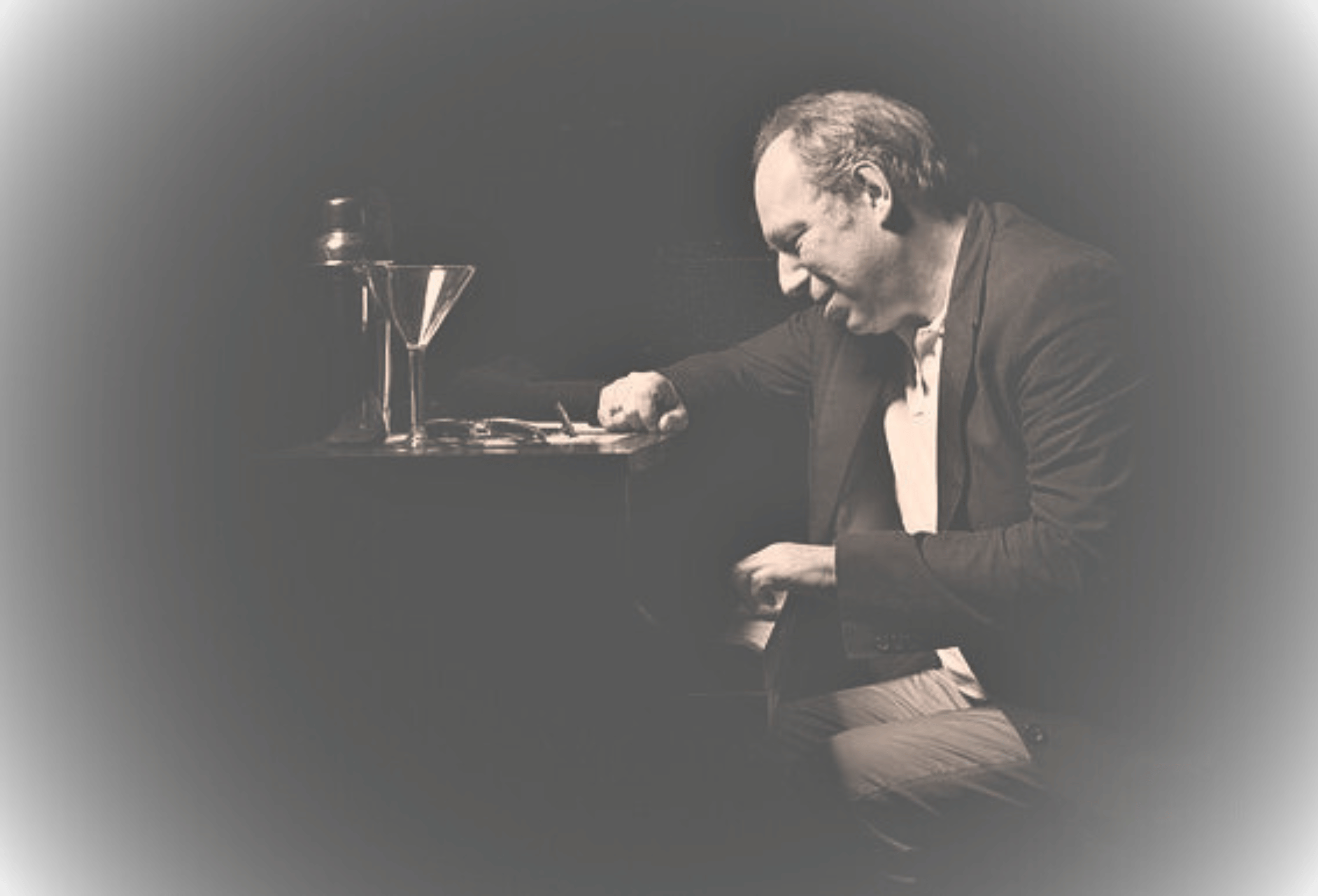 Hans Zimmer composer intently creates music in a sophisticated, dark-toned VIP setting with barware.