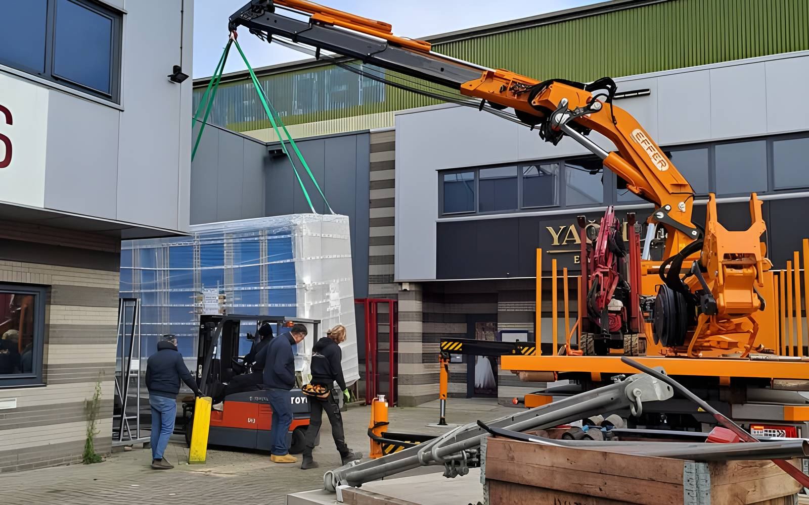Een order isolatieglas wordt met de kraan op het transport geladen bij de hal aan de Nieuwe Hemweg