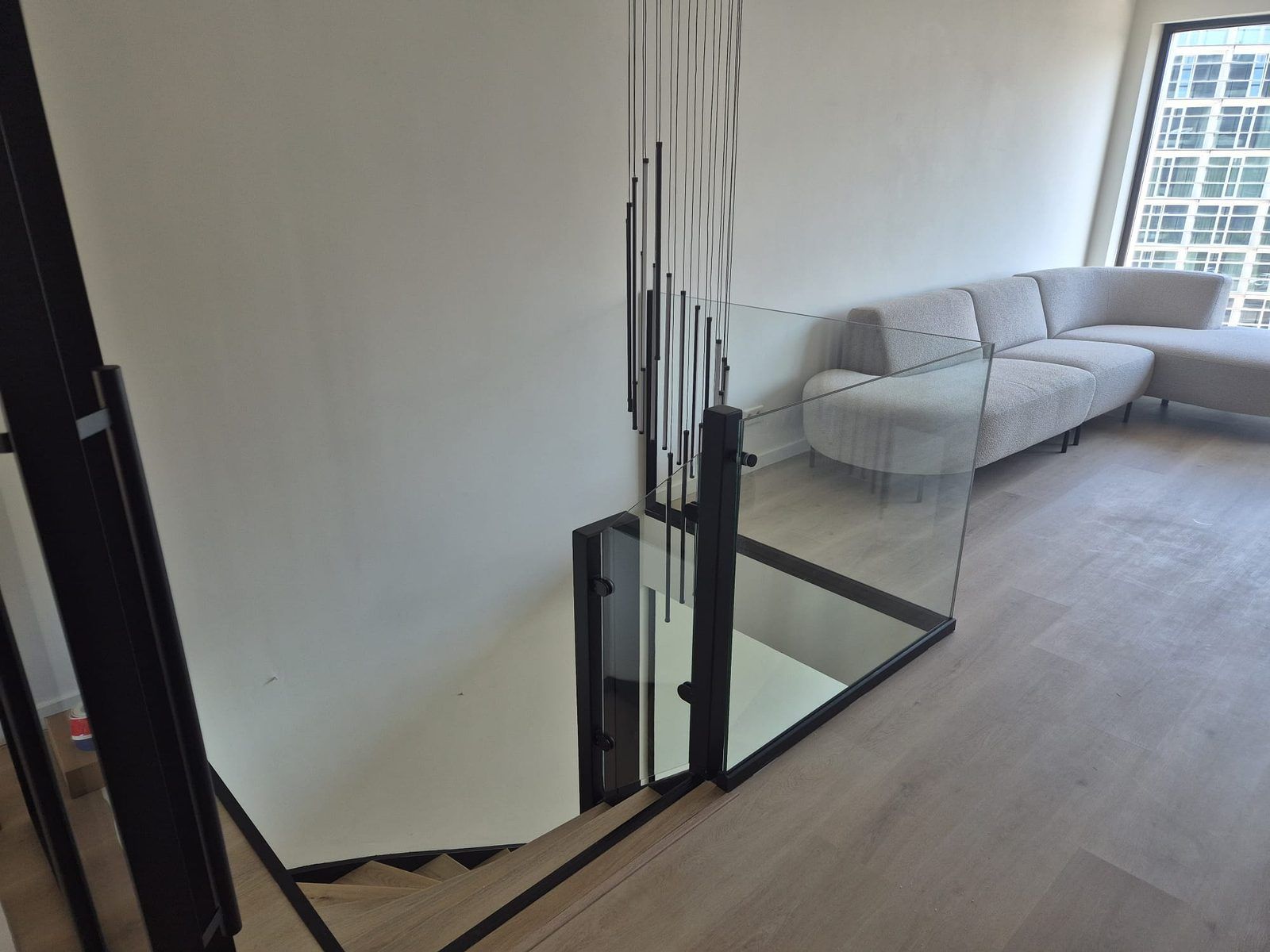 Glazen wand met zwart profiel, uitgevoerd door HGI Glas
