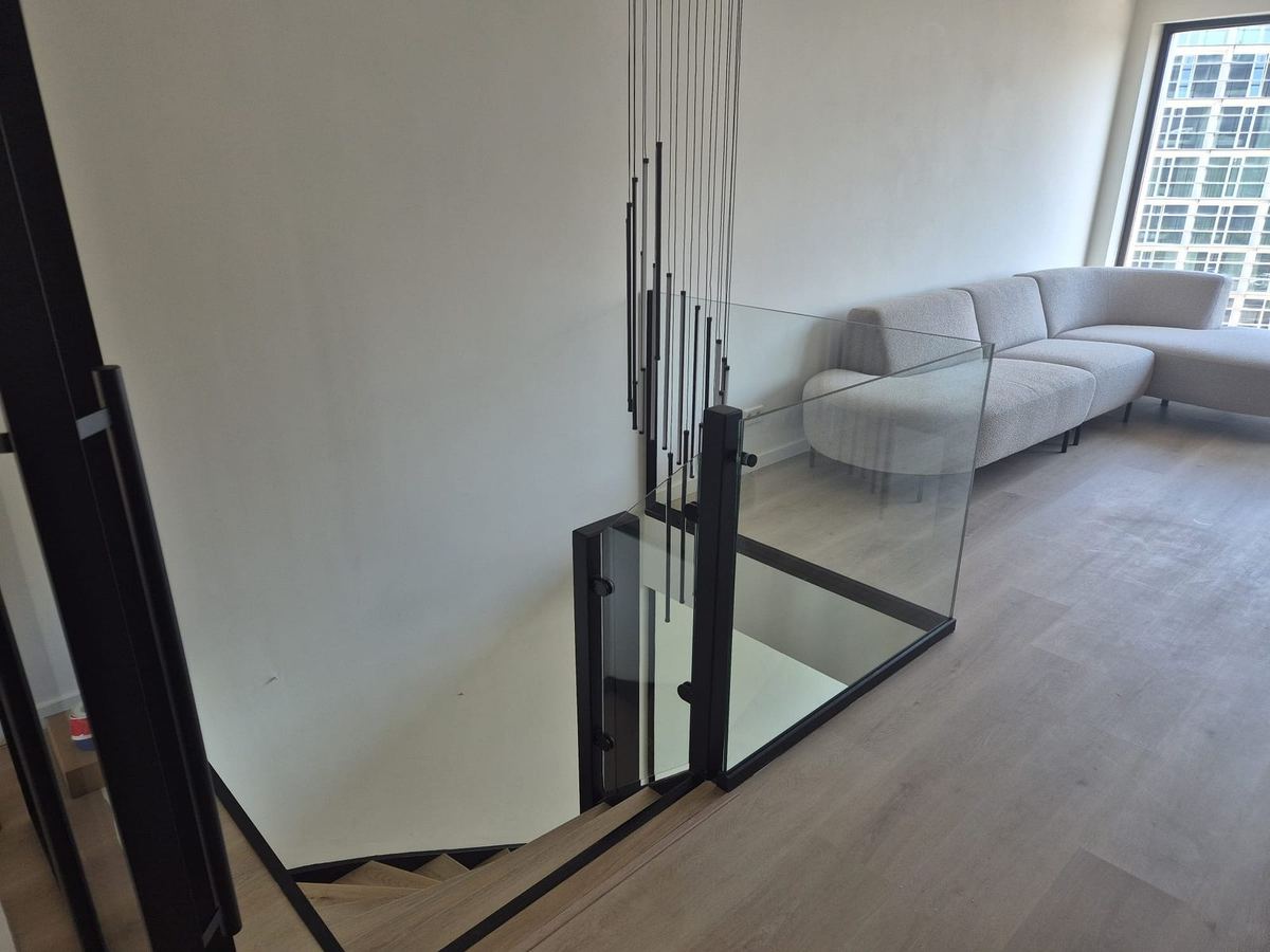 Glazen wand met zwart profiel in een woning in Amsterdam, gemaakt en geplaatst door HGI