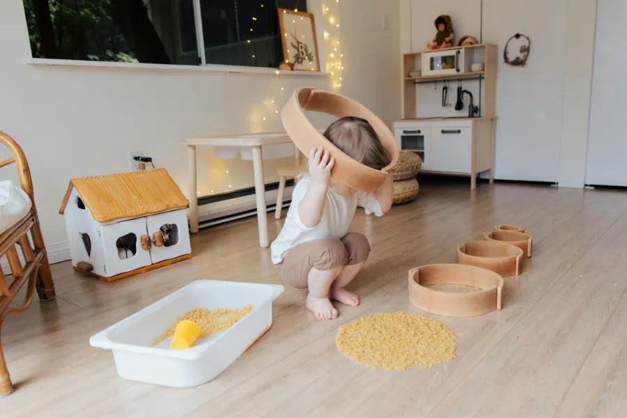 zdjęcie dziecka podczas zajęć integracji sensorycznej, dziecko bawiące się nasionami, makaronem w terapii sensorycznej