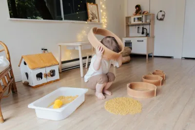zdjęcie dziecka podczas zajęć integracji sensorycznej, dziecko bawiące się nasionami, makaronem w terapii sensorycznej