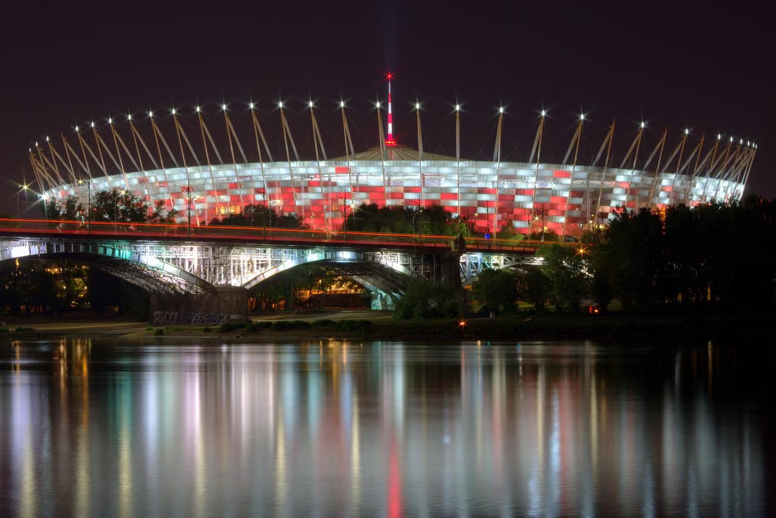 Stadion Narodowy w Warszawie nocą, iluminacja odbita w Wiśle