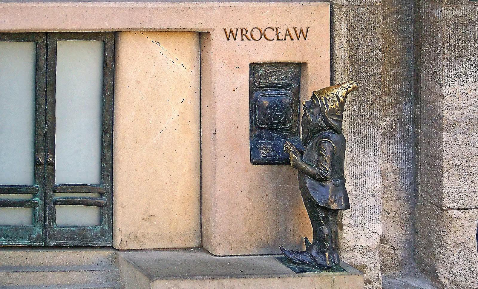 Wrocławski krasnal przy tablicy z napisem Wrocław