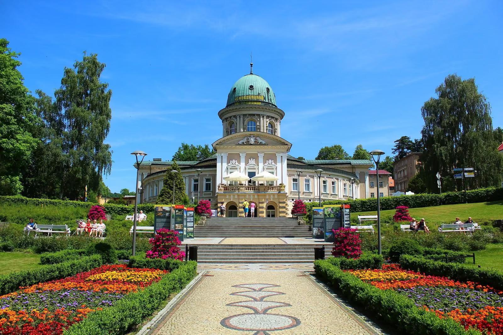 Zdrój w Lądku-Zdroju z kopułą, przed nim kwietne rabaty parku zdrojowego
