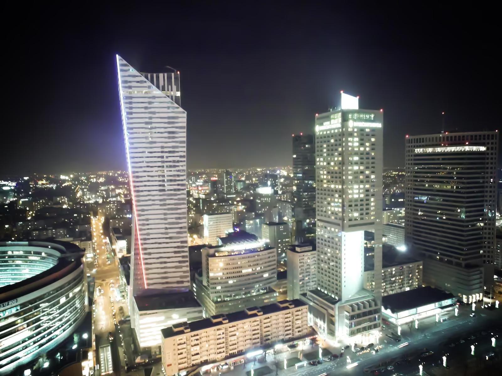 Warszawskie wieżowce nocą, rozświetlone szklane fasady
