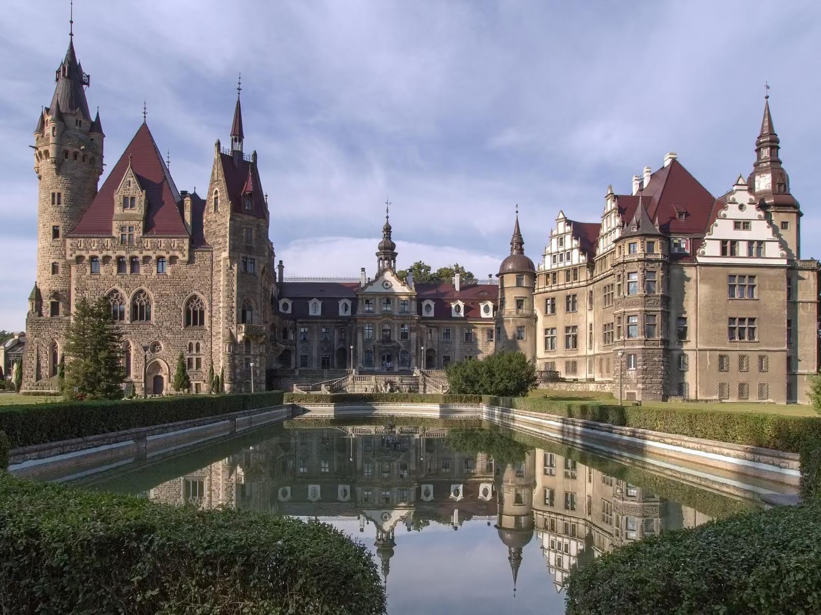 Zamek Moszna odbity w prostokątnym stawie