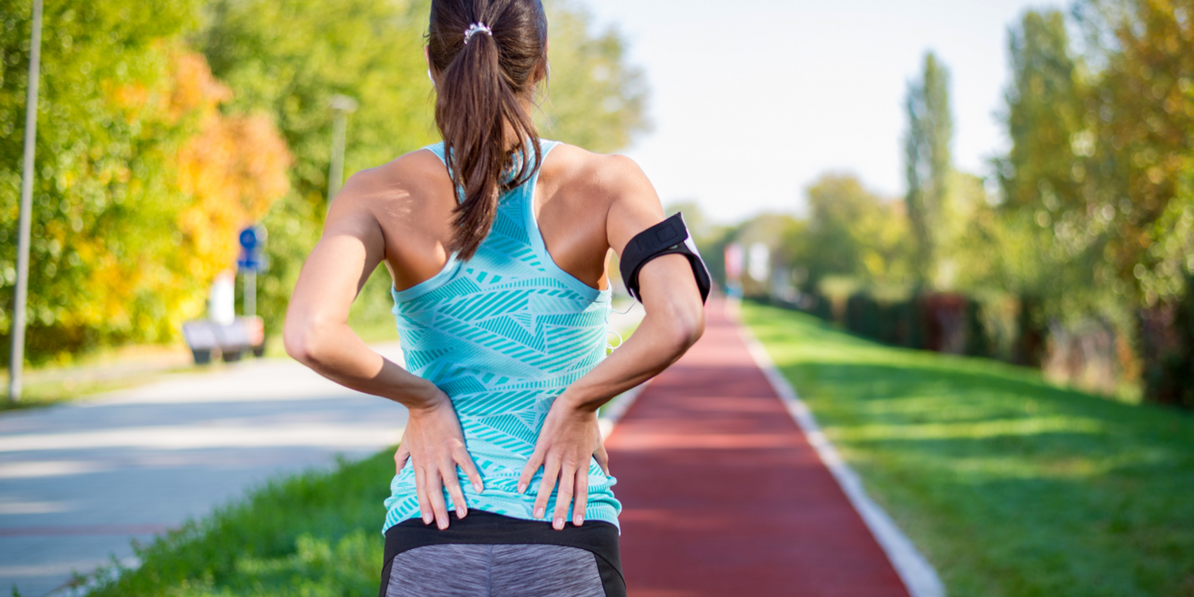 Bild einer Läuferin mit Schmerzen im unteren Rücken