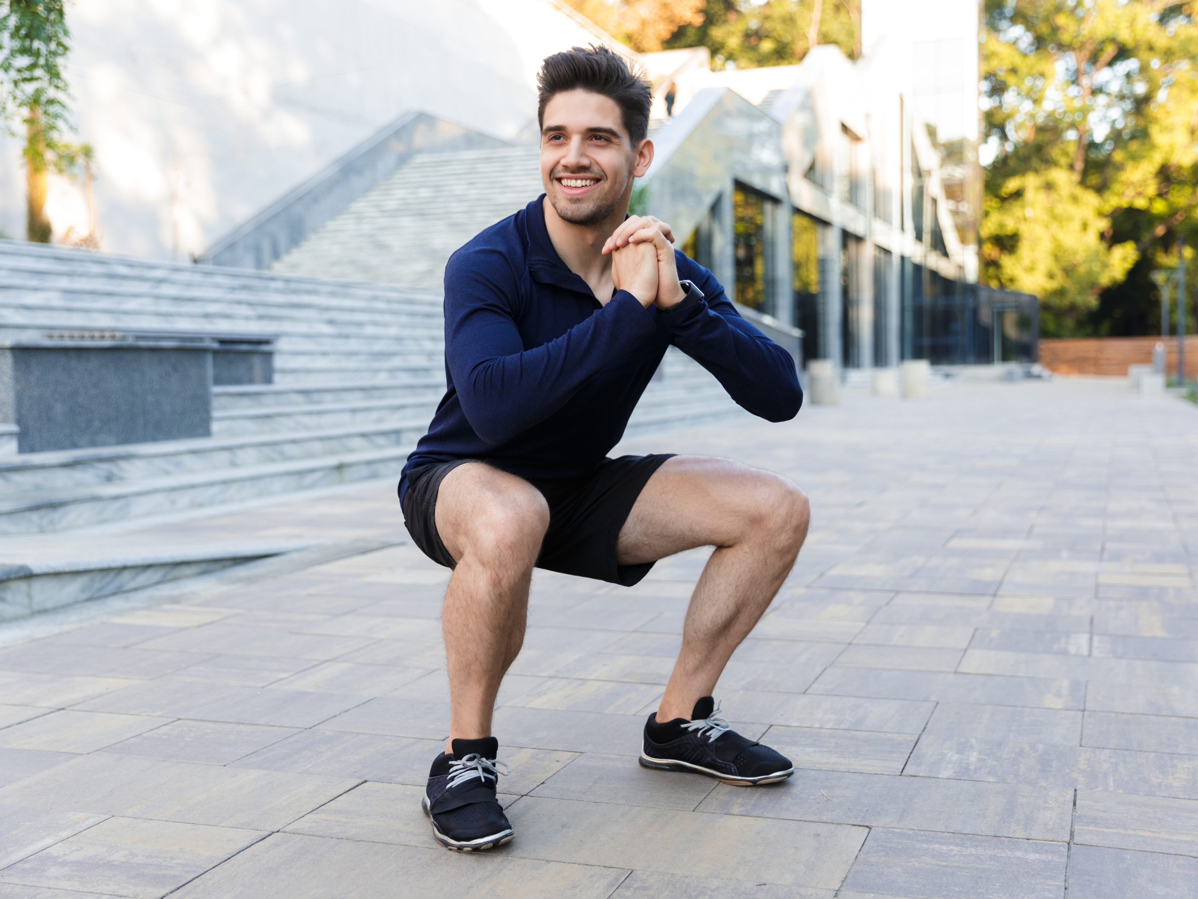 Man performing bodyweight squat as an exercise for patellar tendonitis. 