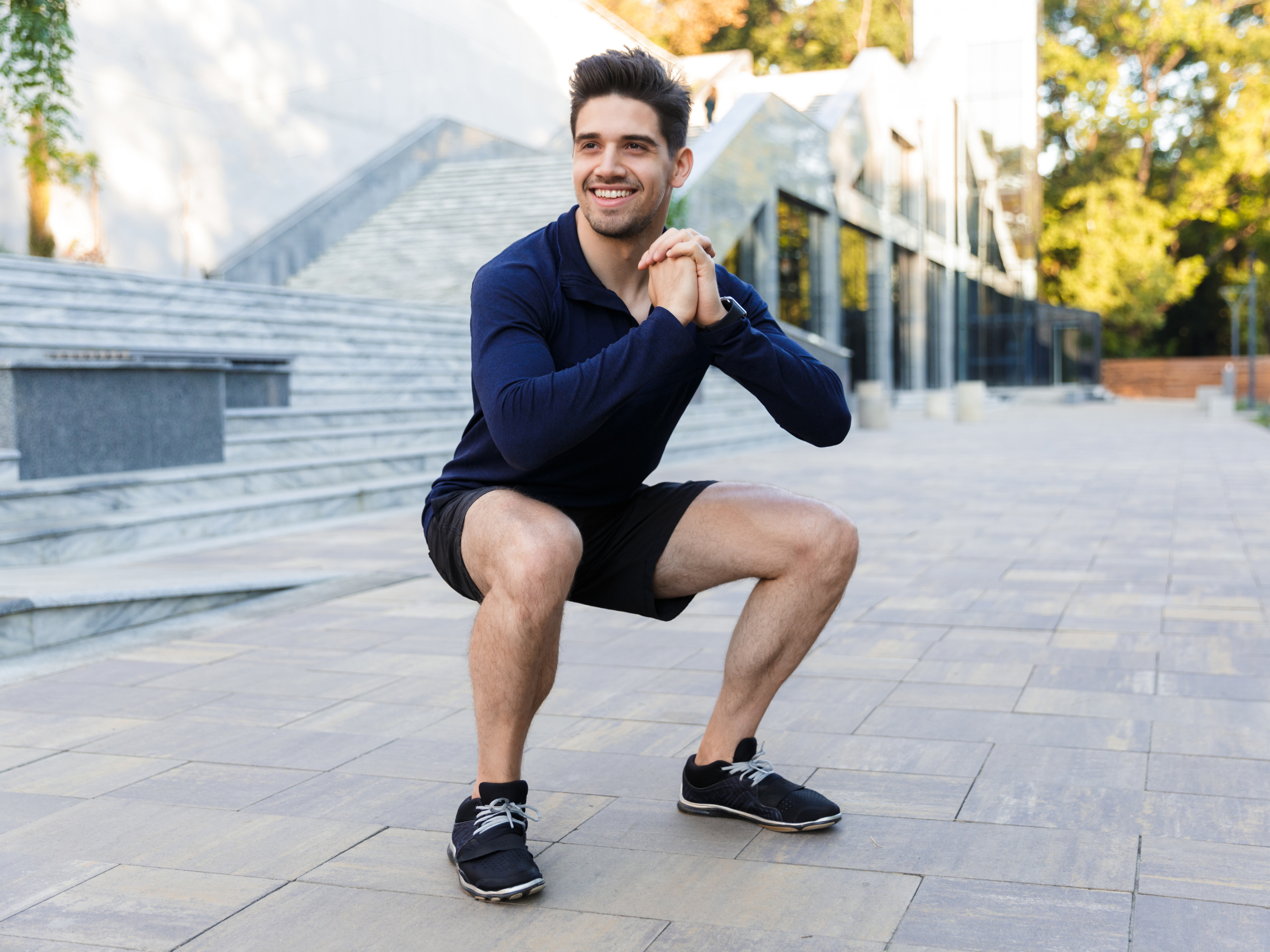 Man performing bodyweight squat as an exercise for patellar tendonitis.