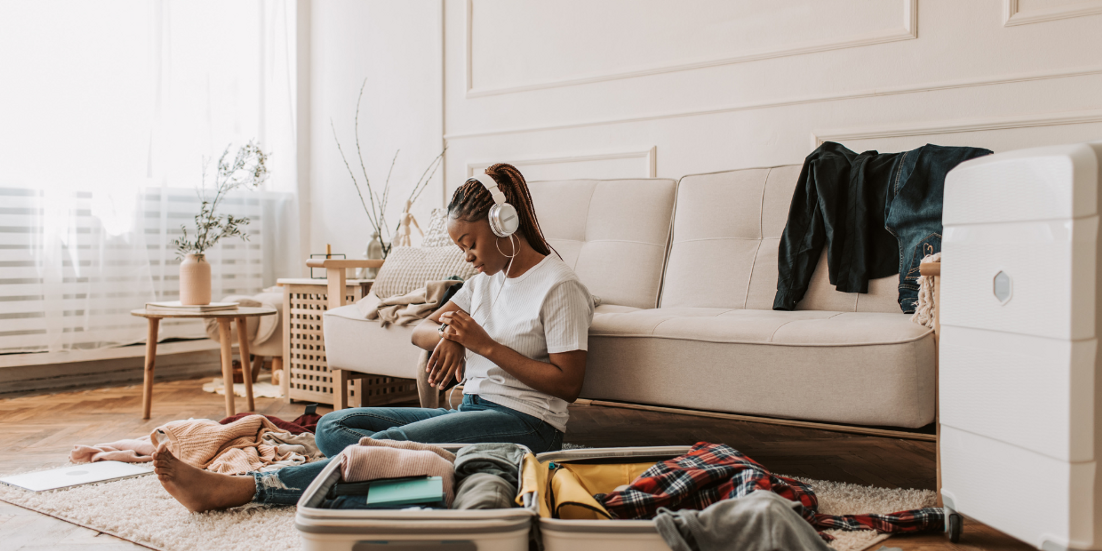 Woman packing her suitcase and checking the time