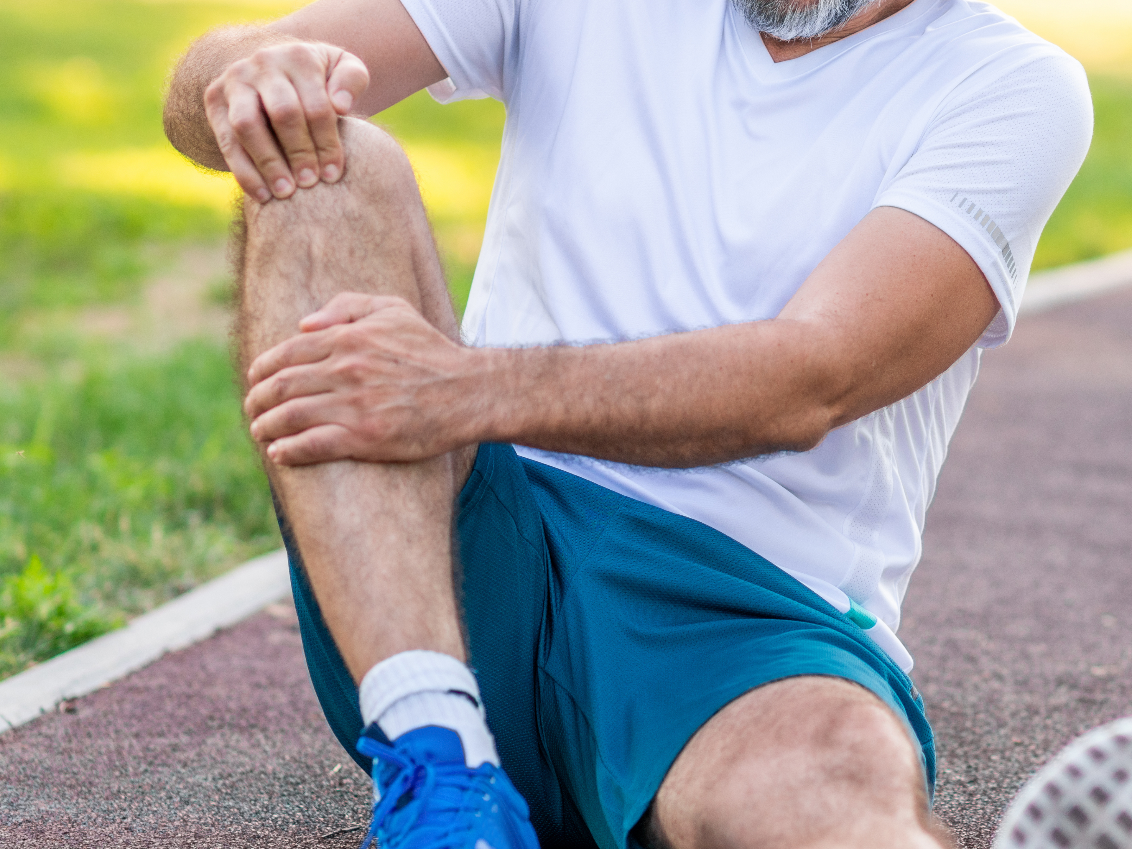 Man holding his knee because of patellar tendonitis pain.