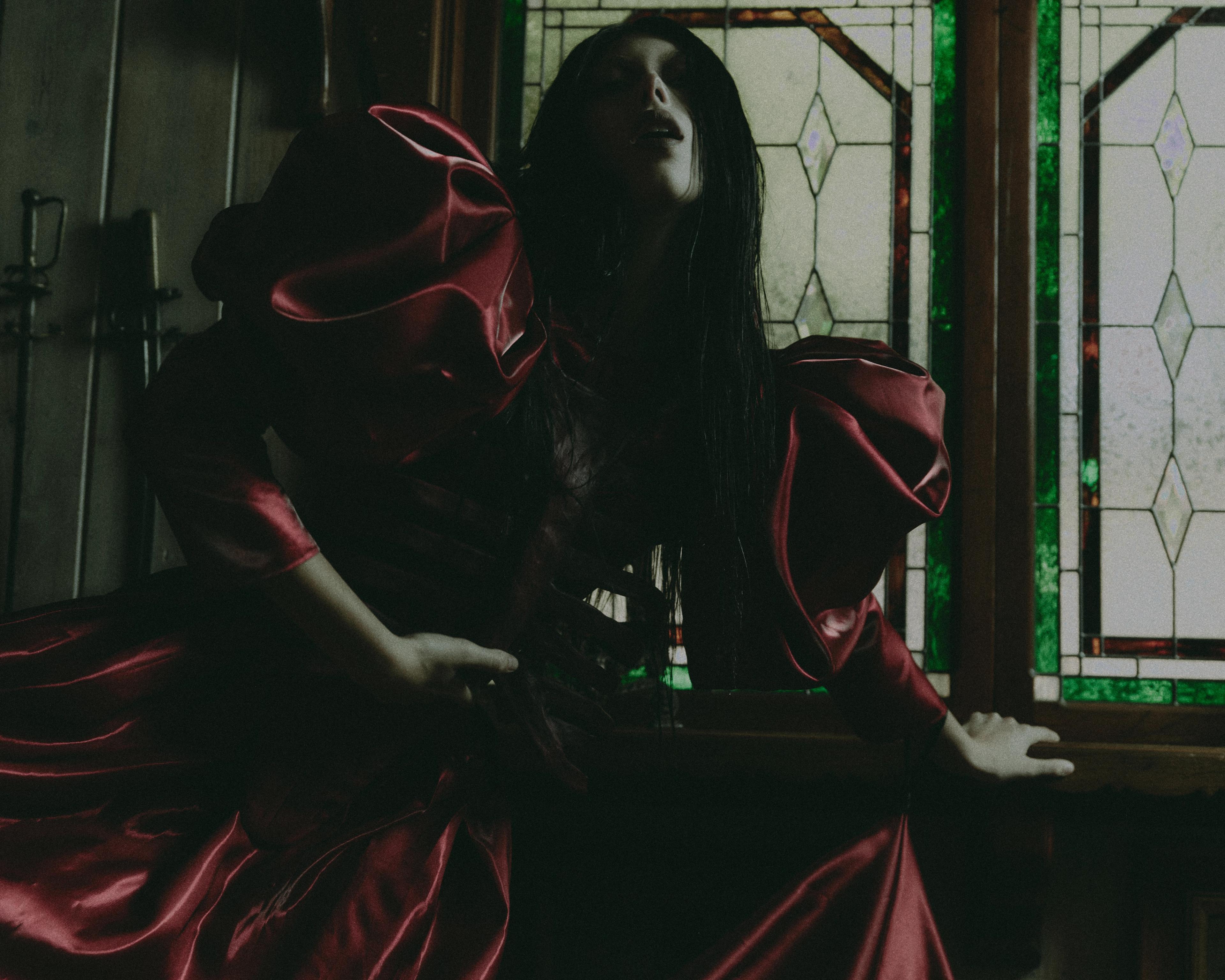 Burgundy sculptural dress photographed against stained glass for Nasty magazine.