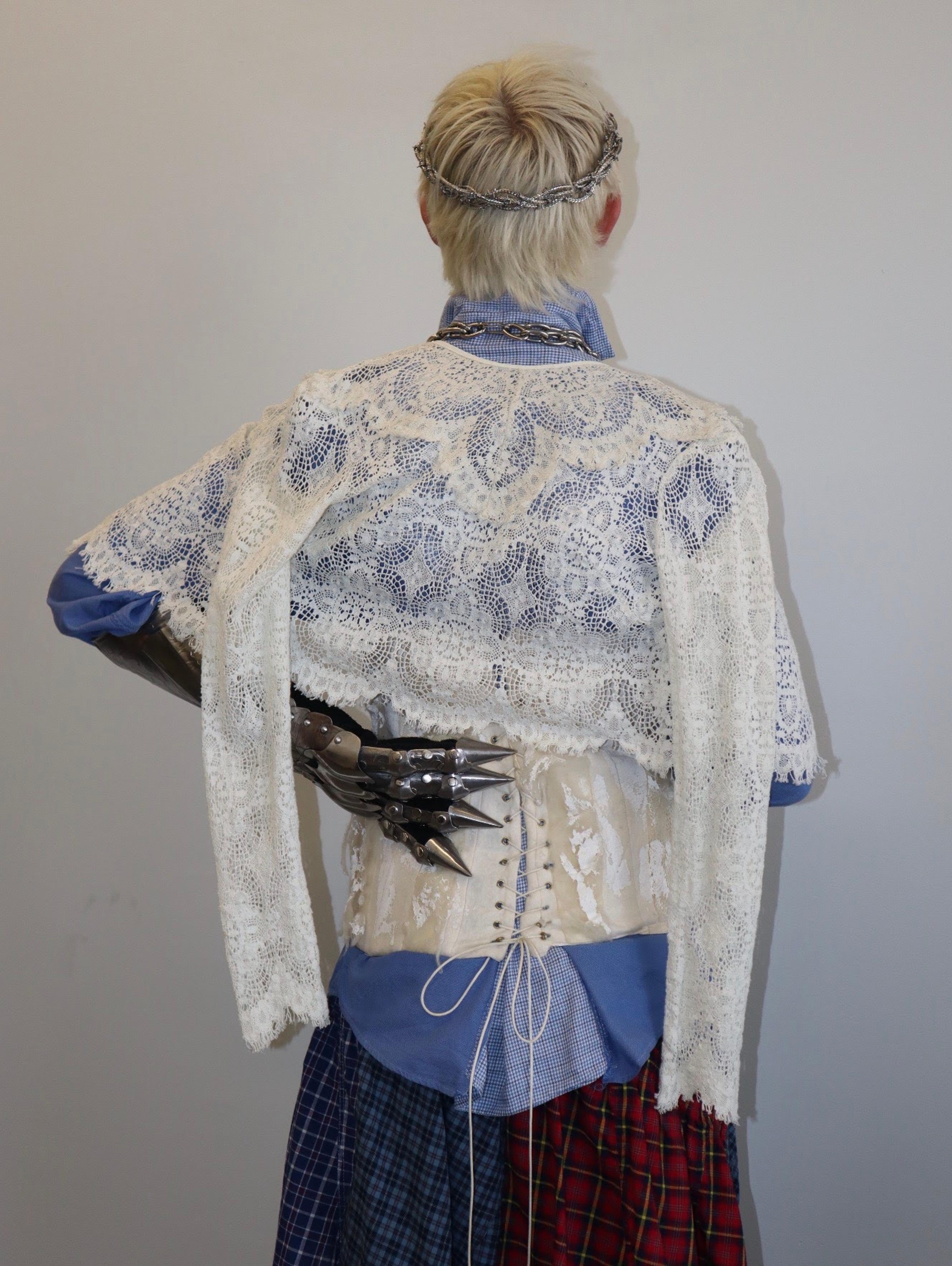Back view of a lace and corset look layered over blue shirting.