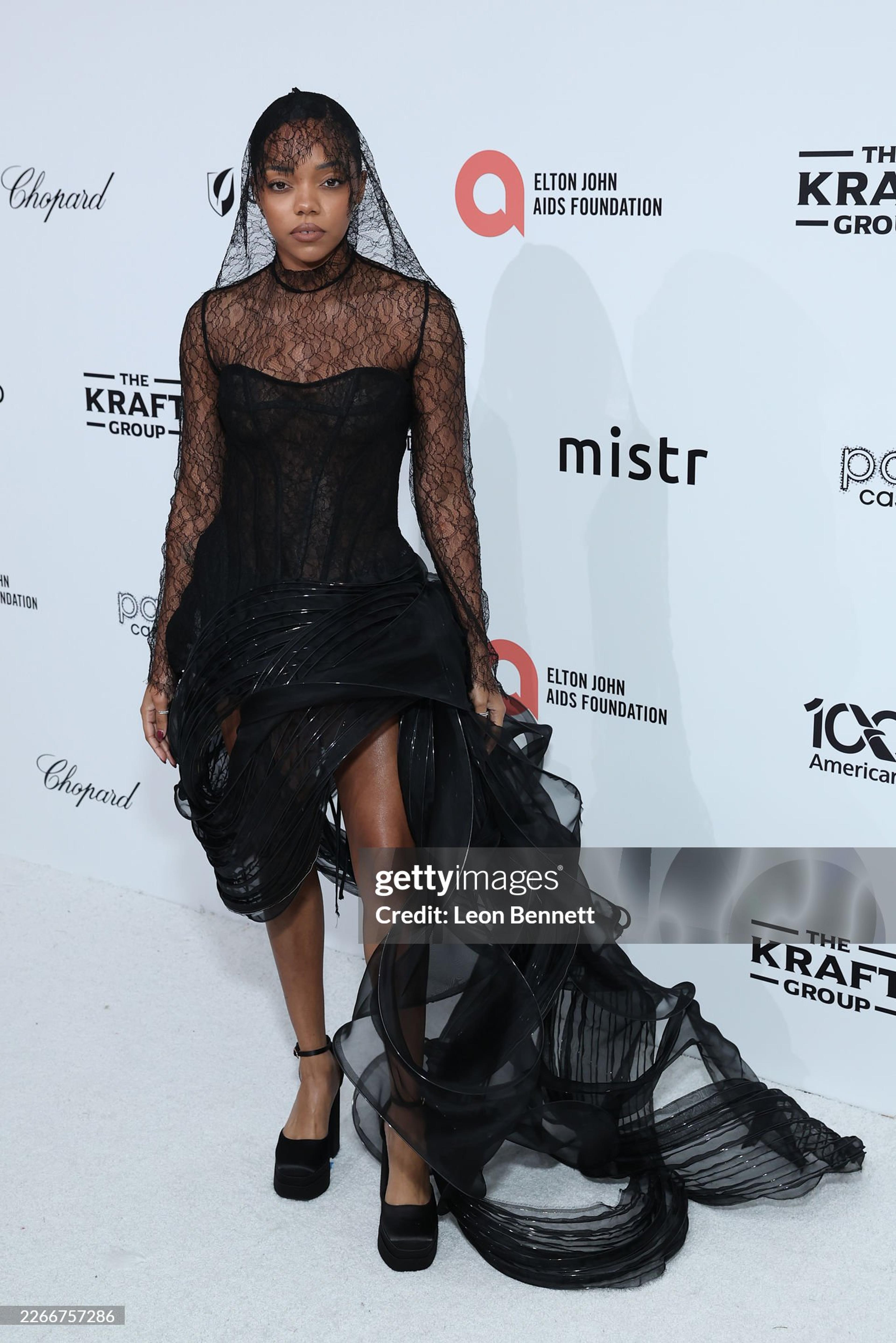 Regan Aliyah on white carpet at an event wearing all black lace swirl Luxi Deng look with black lace veil.