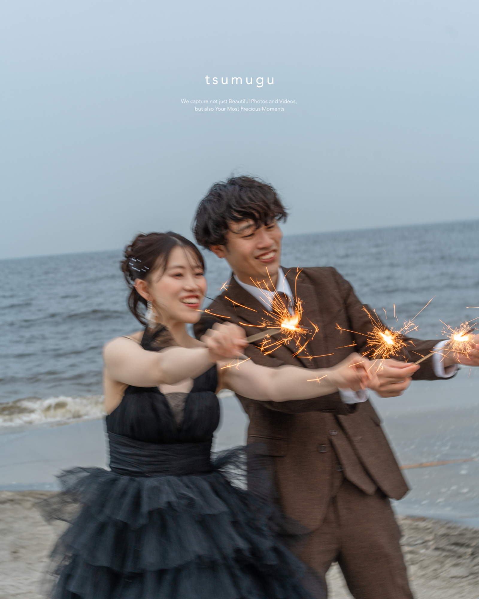 稲毛海浜公園の海辺で手持ち花火を動かして笑うふたり